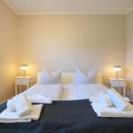 Schlafzimmer mit Doppelbett, zwei Nachttischen und Wandbild.