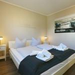 Schlafzimmer mit Bett, zwei Nachttischen und Wandbild.