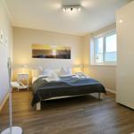 Schlafzimmer mit Bett, Nachttischen und Fenster