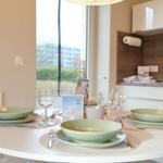 Rundtisch mit Geschirr und Flasche vor Fenster