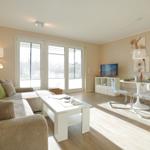 Wohn- und Essbereich mit Sofa, Esstisch und TV.