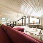 Wohnbereich mit rotem Sofa, Glas-Tisch und großen Fenstern.