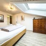 Schlafzimmer mit Dachschrägen, Dachfenster, Holzboden und Schrank.