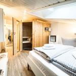 Schlafzimmer mit Bett, Sauna und TV.