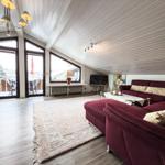 Wohnzimmer mit rotem Sofa, Glasboden und großen Fenstern zur Terrasse.