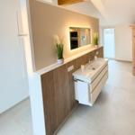 Modern bathtub with wood cladding and illuminated mirror