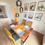 Dining table with four chairs and ceiling lights on the wall.