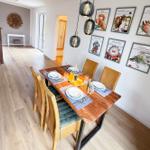 Dining room with wooden table, chairs, and wall pictures