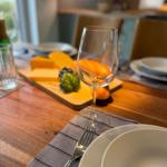 Set table with wine glass and cheese on wooden board