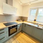 Kitchen with gray cabinets, wooden surfaces, and window view.