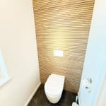Toilet with wooden wall and toilet paper holder