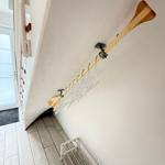Wall-mounted rack with hooks and wooden pole for clothing