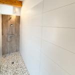 Shower area with wooden wall and stone floor