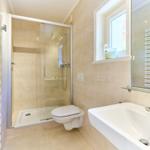 Badezimmer mit Dusche, Toilette und Waschbecken.