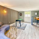 Ein Raum mit Sofa, Billardtisch und Barhockern. Holzwand und Holzboden.