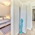 Schlafzimmer mit Bett, Teppich und Decke. Flur mit Kleiderschrank und Seepferdchen-Dekoration.