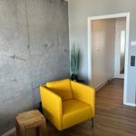 Gelber Sessel neben Betonwand und Holzboden