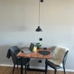 Essbereich mit Holztisch, zwei Stühlen und schwarzem Hängelampen.