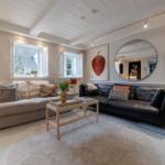Wohnzimmer mit zwei Sofas, runden Spiegeln und einem großen Teppich.