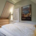 Schlafzimmer mit Doppelbett, Holzschrank und Wandbild Monaco.