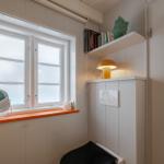 Badezimmer mit Fenster, Spiegel und Nachttischlampe.