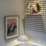 Wohnzimmer mit Pflanze, Lampe und Bild an der Wand.