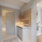 Flur mit Holzregal, Waschbecken und Tür zum Schlafzimmer.