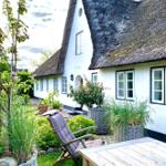 Haus mit Strohdach, Garten mit Liegestuhl und Tisch