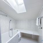Bad mit Dusche, Badewanne und Dachfenster.