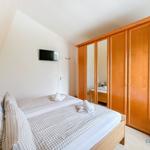 Schlafzimmer mit Doppelbett, Kleiderschrank und TV