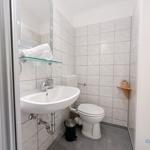 Badezimmer mit Waschbecken, Toilette und Spiegel