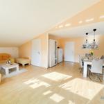 Wohn- und Essbereich mit Sofa, Esstisch und Holzboden.