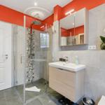 Badezimmer mit Dusche, Waschbecken und Spiegel