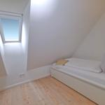 Dachgeschosszimmer mit Fenster und Bett