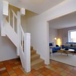 Haus mit Treppenhaus und Wohnzimmer mit blauem Sofa.