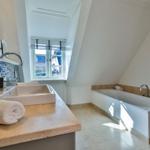 Badezimmer mit Badewanne, Waschbecken und Fenster