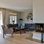 Wohnzimmer mit Kamin, Sofa und Terrassentür