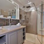 Badezimmer mit Dusche, Waschbecken und Fenster