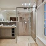 Dusche mit Glaswand, Waschbecken mit Spiegel und Fenster