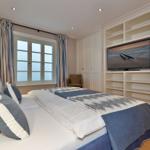 Schlafzimmer mit Bett, TV und Fenster. Holzboden und Einbauschränke.