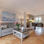 Living and dining area with sofa, table, and kitchen area.