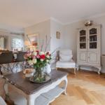 Living and dining area with wooden floor, dining table, sofa, and sideboard.