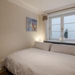 Bedroom with bed, window, and wall art.