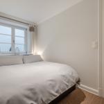 Bedroom with bed, window, and door