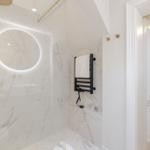 Shower with round mirror and heater, white marble wall