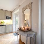 Kitchen with wooden floor, mirror, and candles on console