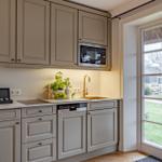 Kitchen with light cabinets, sink, and view of garden