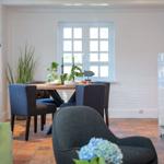 Dining room with table, chairs, and tiled fireplace on the wall.