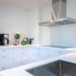Modern kitchen with white cabinets, stainless steel stove, and countertop.