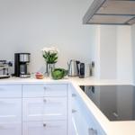 Kitchen with white cabinets, cooktop, and kitchen appliances.